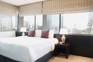 a bedroom with a white bed and large windows at The Quarter Saladaeng by UHG in Bangkok +126 photos