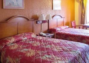 een hotelkamer met 2 bedden en rode dekens bij Rodeway Inn in Forsyth