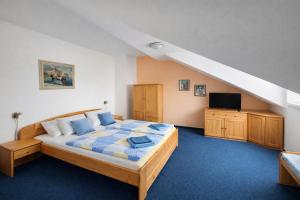 a bedroom with a large bed and a tv at hotel Sádek in Díly +65 photos