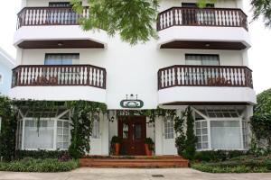 Casa blanca con puerta roja y balcones en Villa Germânia, en Balneário Camboriú