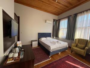 a bedroom with a bed and a tv and a chair at Grand Bedir in Istanbul