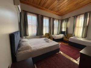 a bedroom with a bed and a couch and windows at Grand Bedir in Istanbul