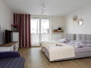 a bedroom with a bed and a tv and a window at Manhattan Place Apartament in Warsaw