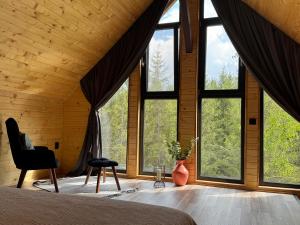 a bedroom with large windows in a wooden house at Apusenity Resort I Piscină Interioară & Cabane în Natură in Cluj-Napoca +34 photos