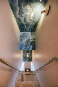 a staircase with a ceiling with clouds on it at Insel der Sinne See-Chalets in Görlitz