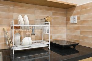 a kitchen with plates and utensils on a shelf at Sai Gon Stay-Hi-Tech Park Collection in Ho Chi Minh City +74 photos