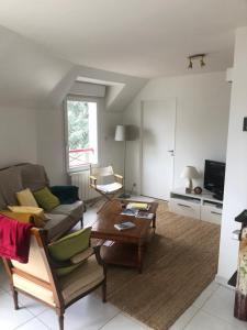 a living room with a couch and a table at Armorique résidence in Malestroit