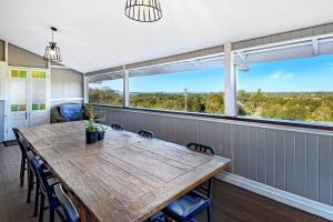 a dining room with a table and chairs and a large window at Kin Kin Farm House - Pets Allowed in Kin Kin