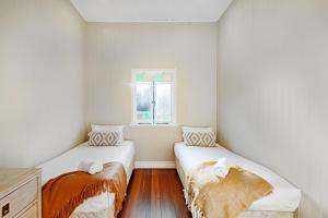 two beds in a small room with a window at Kin Kin Farm House - Pets Allowed in Kin Kin +21 photos