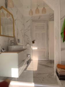 a bathroom with a sink and a mirror and a door at Villa Maria Rosaria in Oborniki Śląskie