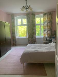 a bedroom with a bed and two windows at Villa Maria Rosaria in Oborniki Śląskie