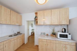 a kitchen with wooden cabinets and a microwave at Hibis, No 1 in Starigrad