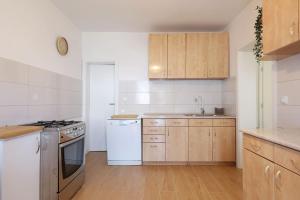 a kitchen with white appliances and wooden cabinets at Hibis, No 1 in Starigrad +13 photos