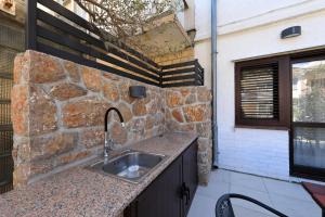 a kitchen with a sink and a stone wall at Hibis, No 1 in Starigrad