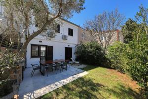 a patio with a table and chairs in a yard at Hibis, No 1 in Starigrad