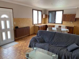 a living room with a couch and a kitchen at Chambre HABILIS 31 in Auterive