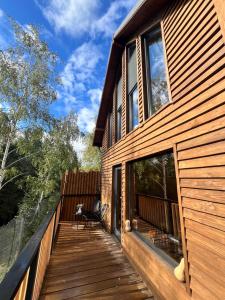 a wooden porch of a house with a deck at Apusenity Resort I Piscină Interioară & Cabane în Natură in Cluj-Napoca