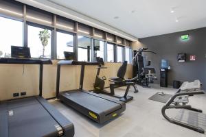 a gym with treadmill and ellipticals in a room with windows at CUBIK inn Design Rooms in Gravina di Catania +61 photos
