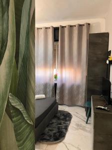 a bedroom with a bed and a window with curtains at LE TEMPLE DU LUXE in Agrigento