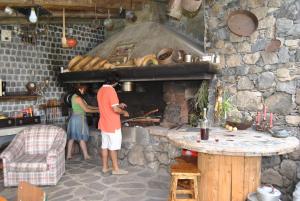 two people standing in front of a stone oven at A Casa Estrelícia-Dourada Garcês in São Vicente