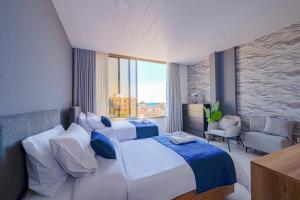 a bedroom with a large bed and a large window at Batroun Staycation in Batroûn