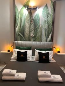 a bed with two pillows and a large painting on the wall at LE TEMPLE DU LUXE in Agrigento