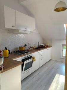 a kitchen with white cabinets and a stove top oven at Villa Maria Rosaria in Oborniki Śląskie +62 photos