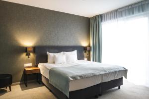 a bedroom with a bed and a large window at Focus Hotel Poznań in Poznań +51 photos
