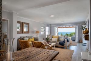 a living room with a couch and chairs and a table at No 5 Cockleshell in Westbrook