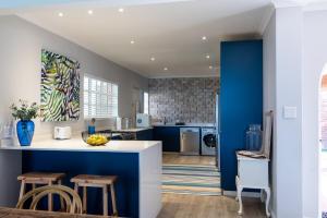 a kitchen with blue walls and a counter with stools at No 5 Cockleshell in Westbrook