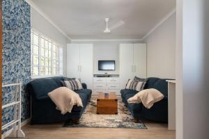 a living room with two blue couches and a tv at No 5 Cockleshell in Westbrook