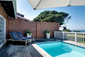 a swimming pool with a chair next to a brick wall at No 5 Cockleshell in Westbrook