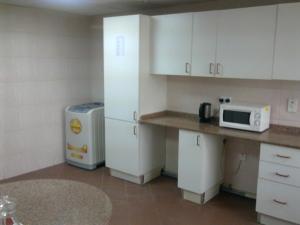 a kitchen with white cabinets and a microwave at Al Zahabiya Hotel Apartments in Dubai