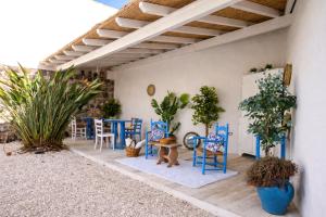 a patio with blue chairs and tables and plants at I Nidi di Dommos - Camere nel centro storico di Orosei in Orosei