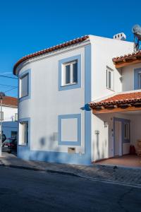a white building with a sign on the side of it at Na Casa da Fátima in Vila Nova de Milfontes