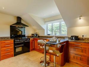 a kitchen with wooden cabinets and a stove top oven at 4 Bed in Torpoint oc-89135 in Sheviock