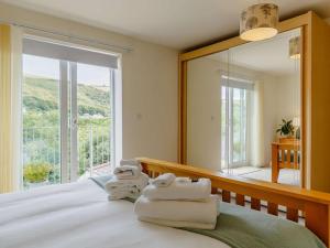 a bedroom with towels on a bed with a large mirror at 4 Bed in Torpoint oc-89135 in Sheviock
