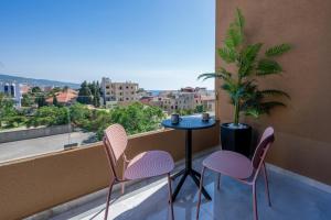 a balcony with two chairs and a table and a palm tree at Batroun Staycation in Batroûn