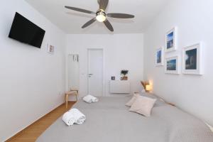 a bedroom with a bed with a ceiling fan at Hibis, No 3 in Starigrad