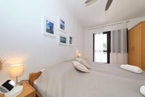a white bedroom with a bed and a window at Hibis, No 3 in Starigrad +17 photos