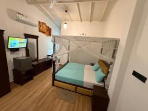 a bedroom with a bed with a canopy and a television at THARUMINI villa in Kandy