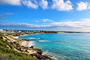 a view of a beach with blue water and buildings at BlueSky Arniston Boutique Guesthouse in Arniston