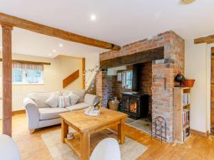 a living room with a couch and a brick fireplace at 1 Bed in Pershore oc-redco in Upton Snodsbury