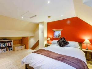 a bedroom with a large bed with an orange wall at 1 Bed in Pershore oc-redco in Upton Snodsbury
