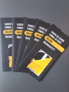 a group of four black cards with yellow labels at Design- und Kunsthotel München in Munich
