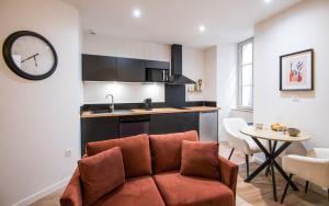 a living room with a couch and a kitchen at Le Choeur in Rodez