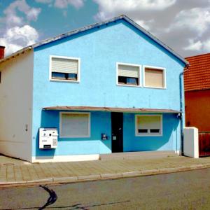a blue house with two windows on a street at Monteurzimmer deSoL in Forst