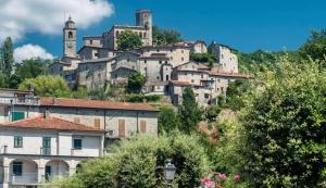 a town on a hill with a clock tower at The River House in Bagnone