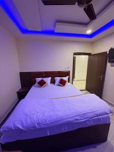 a bedroom with a bed with blue lights on the ceiling at Royal Night Hotel & Resort in Gaya