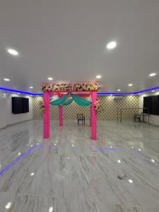 a large banquet hall with a pink table with flowers at Royal Night Hotel & Resort in Gaya